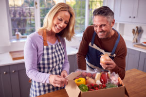 Couple looking inside their meal kit delivery service box